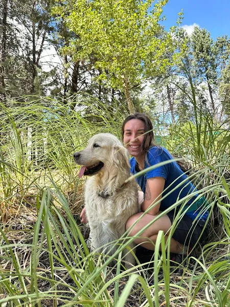 Cuidadora junto a un perro golden retriever en zona verde almacan residencia canina