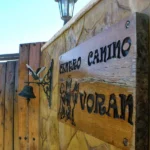Cartel de madera en la entrada con el nombre educadores caninos voran y siluetas de perros