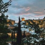 Panorámica del casco antiguo y el castillo iluminado al atardecer con casas blancas y cipreses, harpocan labradores en plasencia caceres 1 scaled.