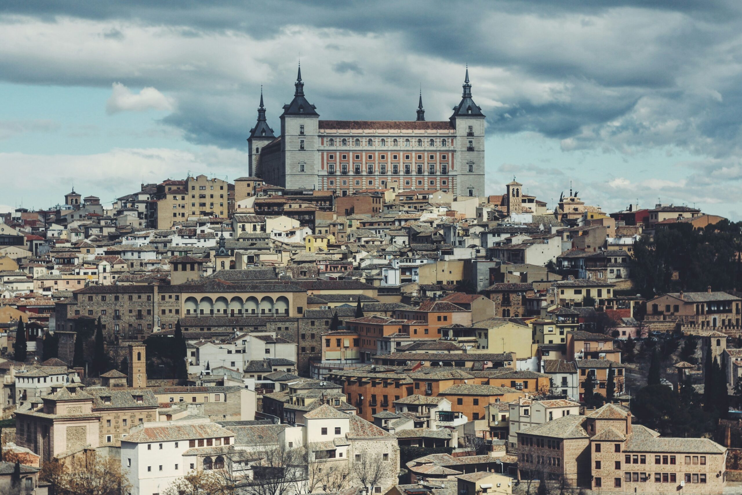 Panorámica urbana con tejados tradicionales y un imponente edificio en la cima hotel canino furby friends en palomeque toledo 1 scaled.